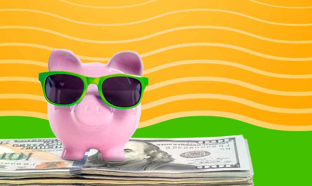 piggy bank wearing sunglasses sits atop a stack of U.S. 货币